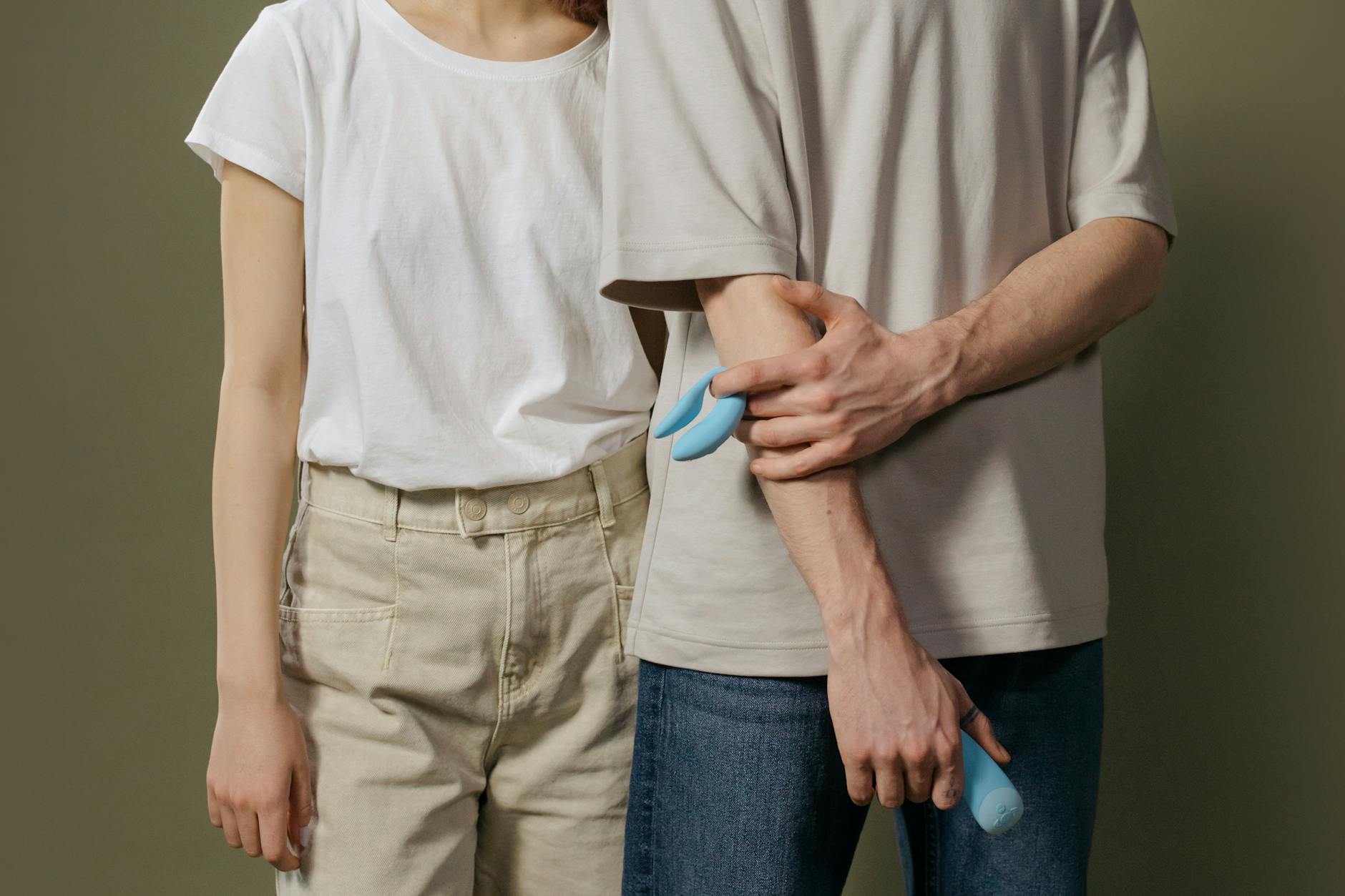 A couple standing together indoors, exploring intimacy with modern tools for pleasure