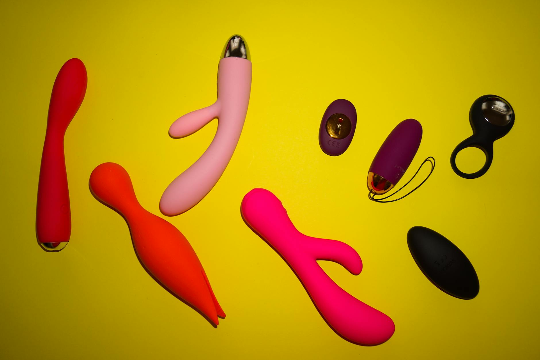 A sleek teal lemon clitoral vibrator resting on smooth white silk fabric