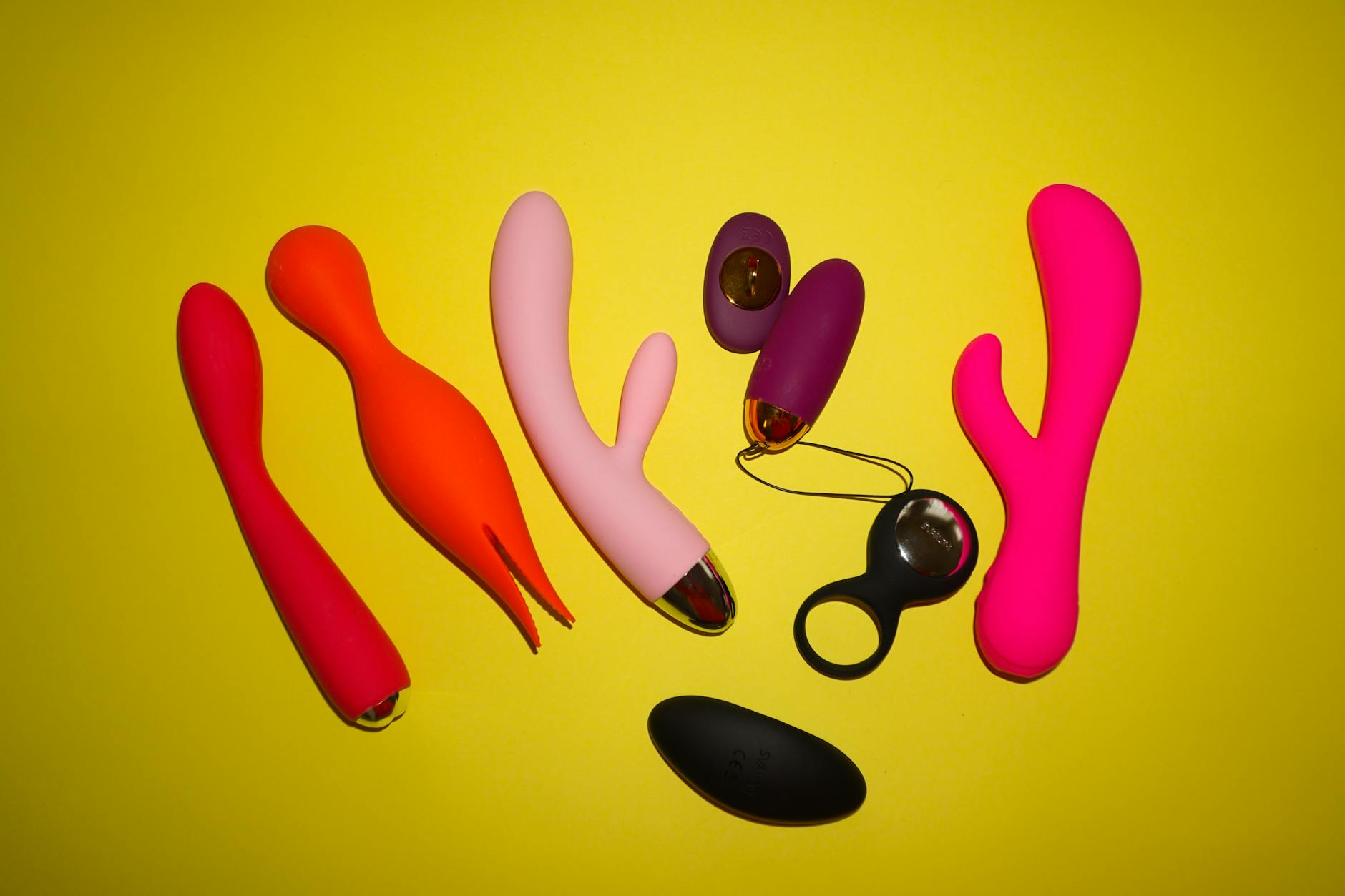 Vibrant collection of colorful lemon sexual toys on a bright yellow background showcasing modern sensuality